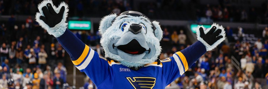 Louie, the St. Louis Blues mascot, cheering with arms raised